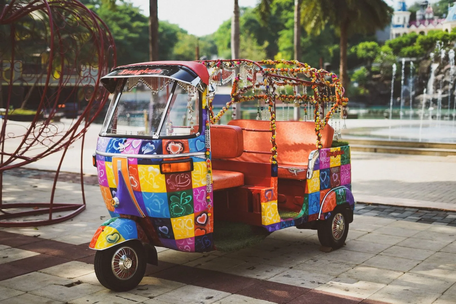 Stock photograph of a three-wheeler with decorative paint, trim and lights; the vehicle and people are unaffiliated with Wanhoo