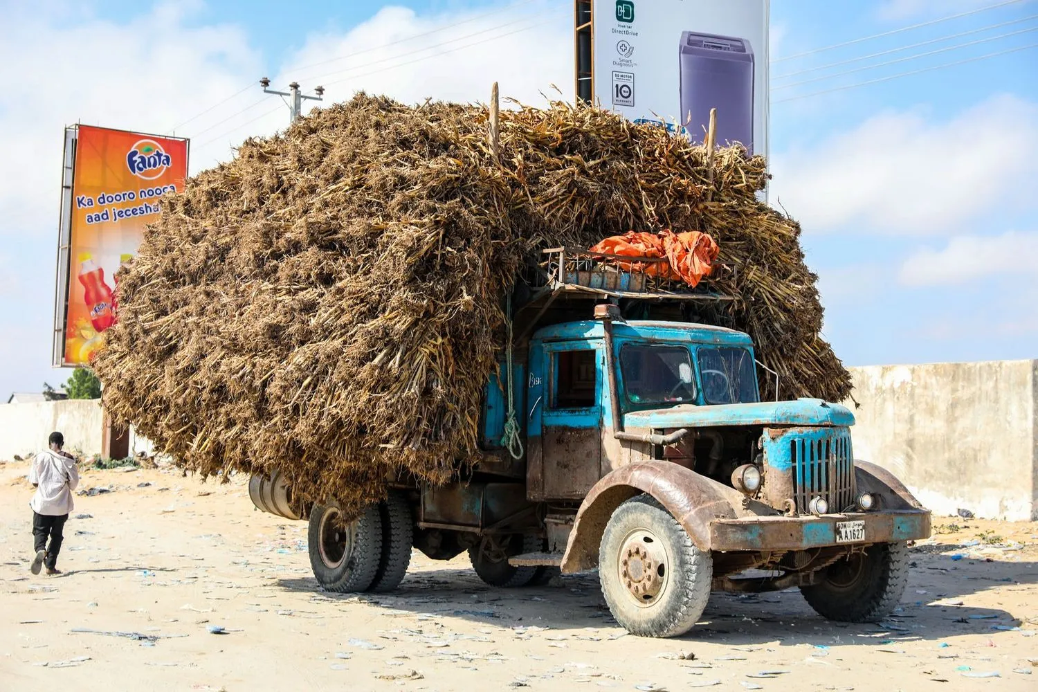 Stock photograph of a heavily loaded vehicle on an unmade road; unaffiliated with Wanhoo