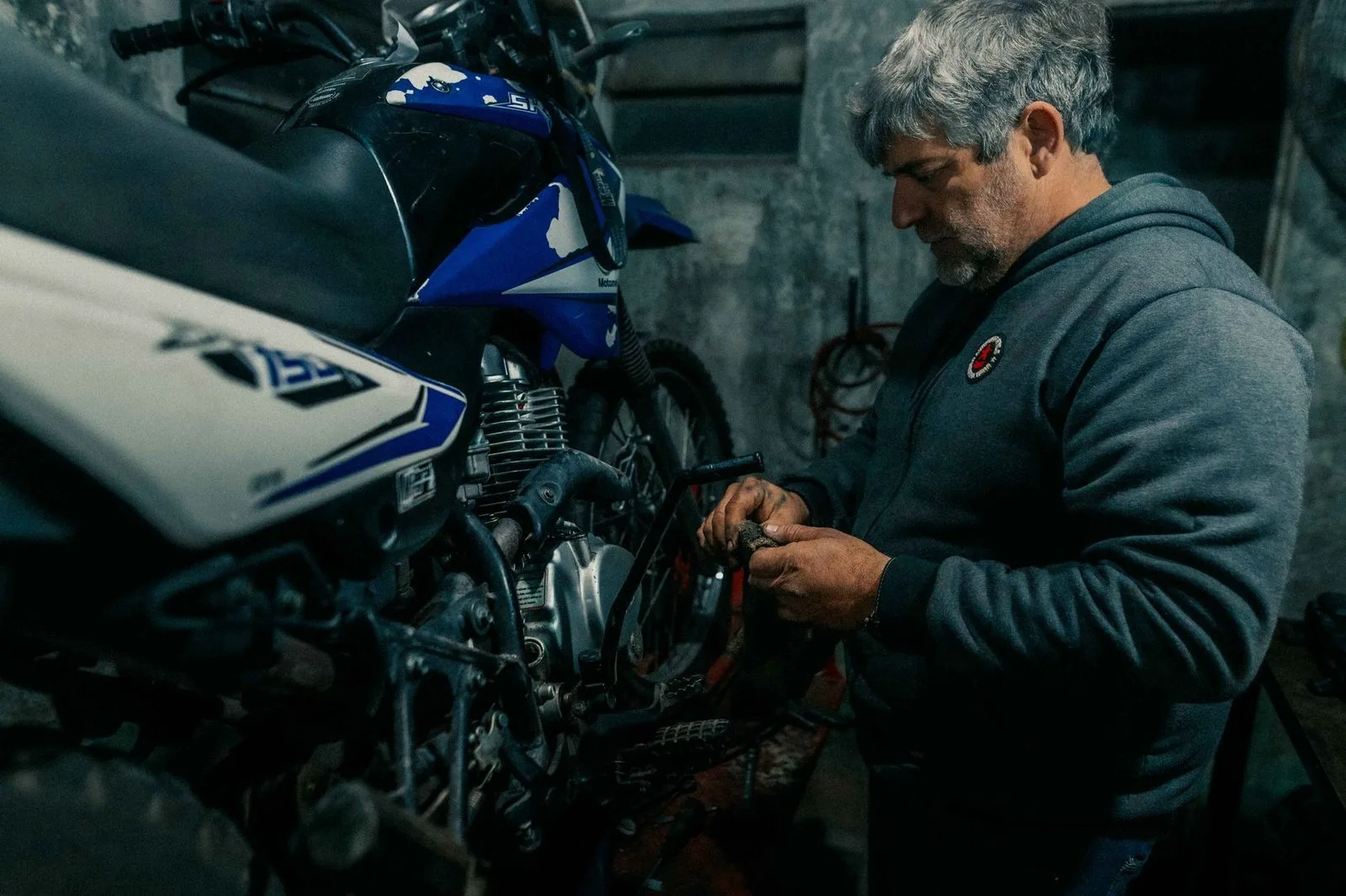 Pexels stock photograph by Gera Cejas, unaffiliated with Wanhoo, showing a mechanic working on a motorcycle