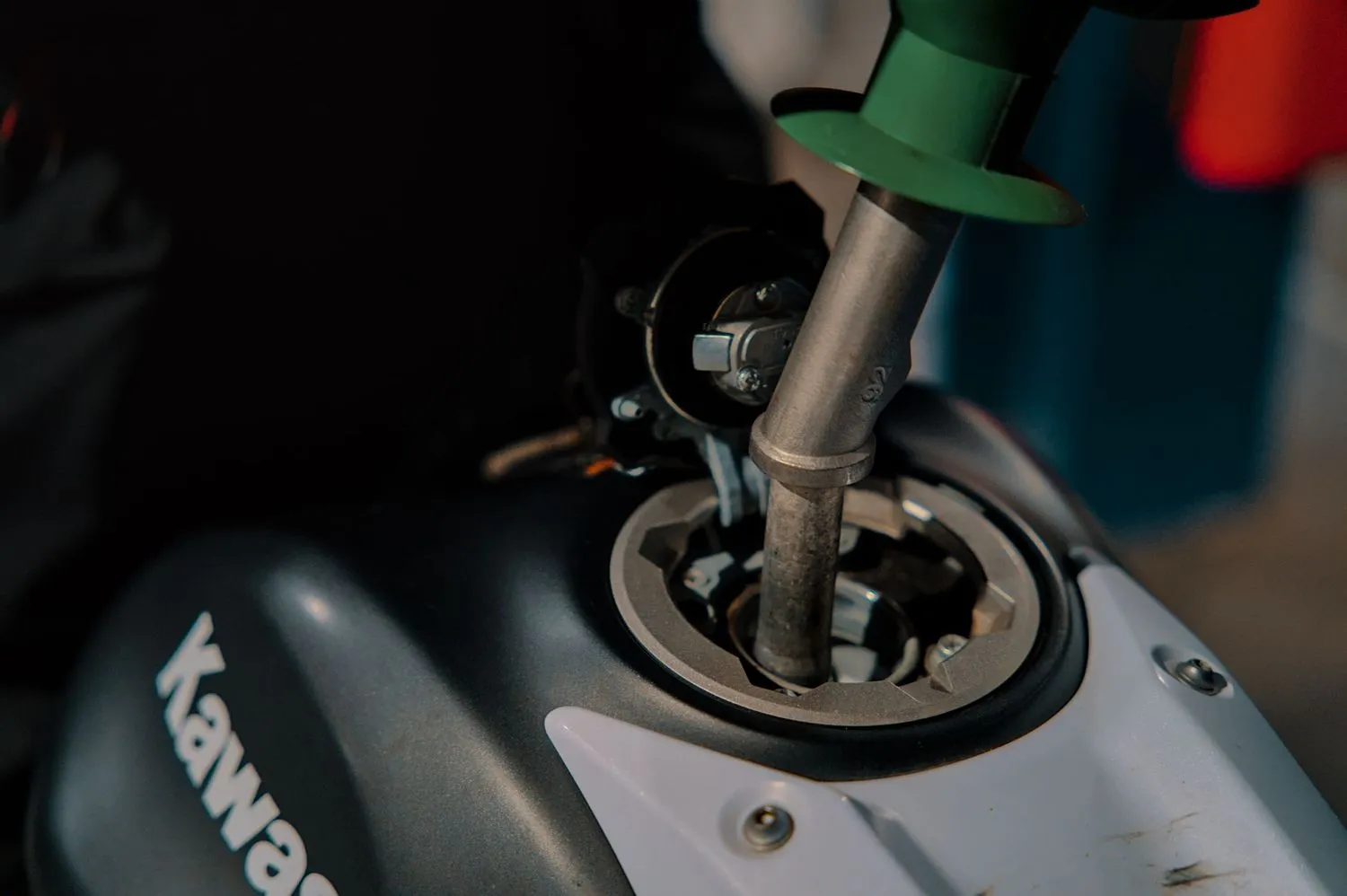 Stock photograph of a motorcycle being refuelled at a fuel pump; unaffiliated with Wanhoo